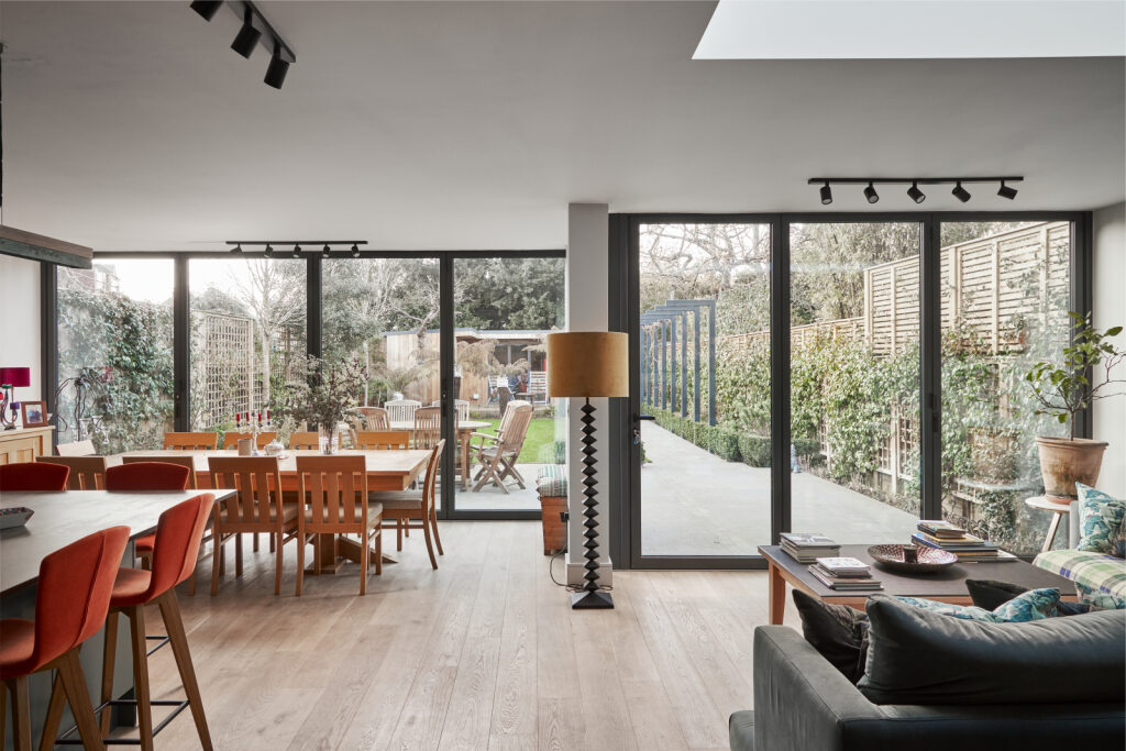 A modern open-plan living space showcasing bi-fold doors to reveal a landscaped garden.